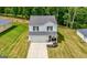 A sunny aerial view shows this home's charming exterior, front yard, and garage amid greenery and neighboring homes at 340 Indian Lake Trl, Villa Rica, GA 30180