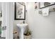 Well-lit powder room features a pedestal sink, decorative mirror and accents that create a modern aesthetic at 340 Indian Lake Trl, Villa Rica, GA 30180