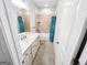 A bathroom features a shower-tub combo with a blue shower curtain and a vanity with a sink at 5229 Tye, Fairburn, GA 30213