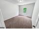 A carpeted bedroom with one window for natural light features neutral white paint and white trim at 5229 Tye, Fairburn, GA 30213