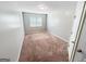 A carpeted bedroom with one window for natural light features neutral gray paint and white trim at 5229 Tye, Fairburn, GA 30213