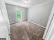 A carpeted bedroom with one window for natural light features neutral gray paint and white trim at 5229 Tye, Fairburn, GA 30213