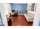 Bedroom with hardwood floors, light gray sofa, blue accent wall and work-from-home setup at 5229 Tye, Fairburn, GA 30213