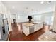 An open-concept kitchen features a large island, granite countertops, stainless steel appliances, and wood floors at 5229 Tye, Fairburn, GA 30213