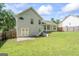 View of a backyard featuring a well-maintained lawn and a partial view of the home's exterior and fenced perimeter at 5832 Whitney Way, Rex, GA 30273