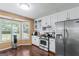 Well-lit kitchen with stainless steel appliances, white cabinetry, and a large window at 5832 Whitney Way, Rex, GA 30273
