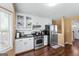 Bright kitchen featuring stainless steel appliances, white cabinets, and hardwood floors at 5832 Whitney Way, Rex, GA 30273
