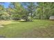 Spacious backyard featuring lush greenery and mature trees, ideal for outdoor activities and relaxation at 288 Winthrop Dr, Sharpsburg, GA 30277