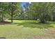 Lush green backyard with mature trees and a storage shed, perfect for outdoor activities and relaxation at 288 Winthrop Dr, Sharpsburg, GA 30277