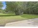 Expansive green backyard with mature trees and a storage shed, offering a serene outdoor space at 288 Winthrop Dr, Sharpsburg, GA 30277