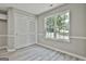 Bedroom with neutral walls, wood-look floors, large window and double door closet at 288 Winthrop Dr, Sharpsburg, GA 30277