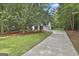 Spacious driveway leads to a well-maintained home with lush green lawn and mature trees, creating a private setting at 288 Winthrop Dr, Sharpsburg, GA 30277