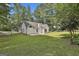 Rear exterior view of the home with a spacious yard, concrete patio, and verdant landscaping at 288 Winthrop Dr, Sharpsburg, GA 30277