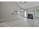 Bright living room with gray walls, wood-look floors, a fireplace, and views into the kitchen at 288 Winthrop Dr, Sharpsburg, GA 30277