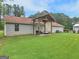 Backyard with a covered patio, grill, lush lawn, and a view of the surrounding greenery at 552 New Hope Rd, Mcdonough, GA 30252