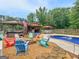 Backyard with pool, pool house, fire pit, comfortable seating, and lush landscaping at 552 New Hope Rd, Mcdonough, GA 30252