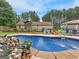 View of the sprawling backyard with an in-ground pool, landscaping, and a charming home at 552 New Hope Rd, Mcdonough, GA 30252