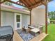 Backyard patio area with comfortable seating, grill, and a view of the lawn and trees at 552 New Hope Rd, Mcdonough, GA 30252