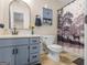 Bathroom with blue vanity, toilet, floral accents, and a shower with a deer-themed curtain at 552 New Hope Rd, Mcdonough, GA 30252