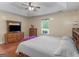 Bright bedroom featuring a tray ceiling, ceiling fan, wood floors, and stylish furnishings at 552 New Hope Rd, Mcdonough, GA 30252