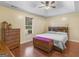 Relaxing bedroom featuring tray ceilings, a dresser, wood floors, and natural lighting at 552 New Hope Rd, Mcdonough, GA 30252