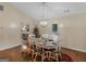 Dining room with a round wood table and white chairs, lit by a modern chandelier, and backyard view at 552 New Hope Rd, Mcdonough, GA 30252