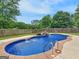 Beautiful in-ground pool features a small stone waterfall and a lush, green backyard at 552 New Hope Rd, Mcdonough, GA 30252
