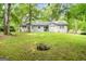 Expansive backyard featuring mature trees, lush grass, and the rear of the house with a patio area at 312 Iron Horse Way, Stockbridge, GA 30281