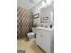 Bright bathroom featuring a single vanity with storage and a decorative mirror at 312 Iron Horse Way, Stockbridge, GA 30281