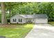 Charming single-story home featuring a well-manicured lawn, gray siding, and a welcoming front porch at 312 Iron Horse Way, Stockbridge, GA 30281