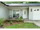 Inviting front porch with seating, decorative plants, and a decorative front door with sidelight windows at 312 Iron Horse Way, Stockbridge, GA 30281