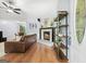 Cozy living room featuring a brick fireplace, hardwood floors, and a comfortable leather sofa at 312 Iron Horse Way, Stockbridge, GA 30281
