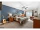 Cozy main bedroom features a ceiling fan, guitar, warm lighting, and natural light from windows at 312 Iron Horse Way, Stockbridge, GA 30281