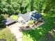 Aerial view of a charming country home surrounded by lush greenery, showcasing its idyllic setting and landscaped yard at 1572 Hines Rd, Moreland, GA 30259