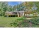 Exterior view of back of home with screened-in porch, wooden deck, and detached carport at 1572 Hines Rd, Moreland, GA 30259