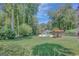Scenic backyard with mature trees features a pool and outdoor kitchen, perfect for entertaining at 1572 Hines Rd, Moreland, GA 30259