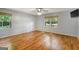 Bright bedroom with hardwood floors, neutral walls, two windows, and a ceiling fan at 1572 Hines Rd, Moreland, GA 30259