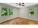 Bright bedroom featuring hardwood floors, neutral walls, and two large windows at 1572 Hines Rd, Moreland, GA 30259