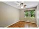Cozy bedroom featuring hardwood floors, neutral walls, and a window view of the yard at 1572 Hines Rd, Moreland, GA 30259