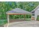 Detached carport with wooden posts and beams, concrete floor, and dark grey shingle roof at 1572 Hines Rd, Moreland, GA 30259