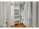 Walk-in closet with custom white shelving and wood floors at 1572 Hines Rd, Moreland, GA 30259