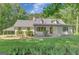 Charming exterior view showcasing the home's white painted brick, front porch, and well-manicured landscaping at 1572 Hines Rd, Moreland, GA 30259