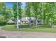 Charming home exterior with a porte-cochere and driveway, framed by lush trees and landscaping at 1572 Hines Rd, Moreland, GA 30259