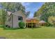 White brick home with wooden deck, large lawn, and detached carport at 1572 Hines Rd, Moreland, GA 30259