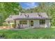 Beautifully renovated home with a modern farmhouse design, featuring a cozy front porch and landscaped yard at 1572 Hines Rd, Moreland, GA 30259