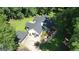 Aerial view of home's front exterior with a well-manicured lawn and a circular driveway at 1572 Hines Rd, Moreland, GA 30259