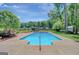 Inground swimming pool with concrete surround, surrounded by mature trees and landscaping at 1572 Hines Rd, Moreland, GA 30259