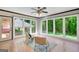 Bright sunroom features large windows overlooking the backyard, tile floor and ceiling fan at 1572 Hines Rd, Moreland, GA 30259