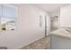 Well-lit bathroom with tile floors, large window, and door leading to another room at 170 Aster Ave, Locust Grove, GA 30248