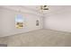 Expansive bedroom featuring plush carpeting, ceiling fan, and large windows offering ample sunlight at 170 Aster Ave, Locust Grove, GA 30248
